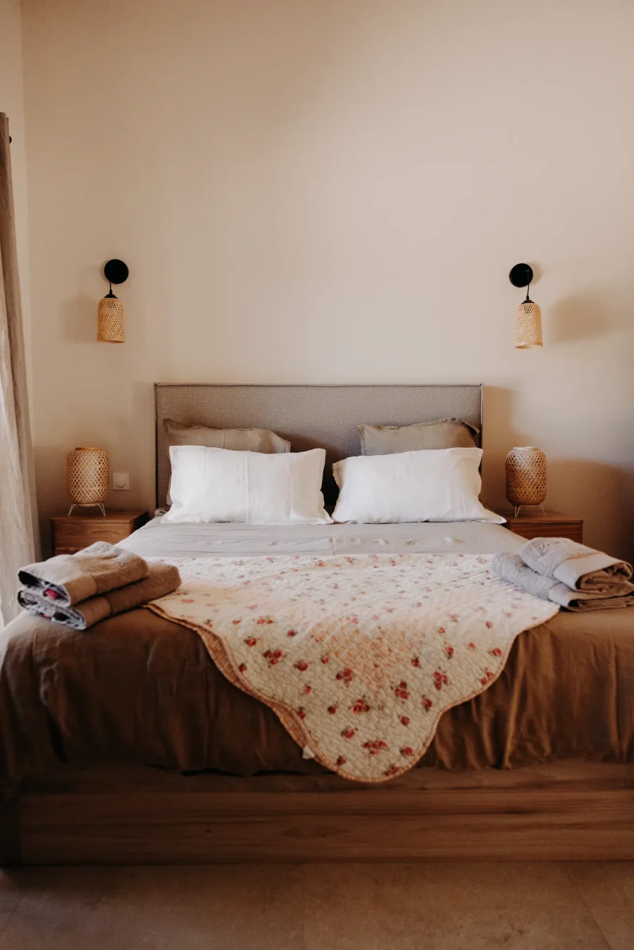 La chambre du rez-de-chaussée, lit double et lampes de chevet en rotin
