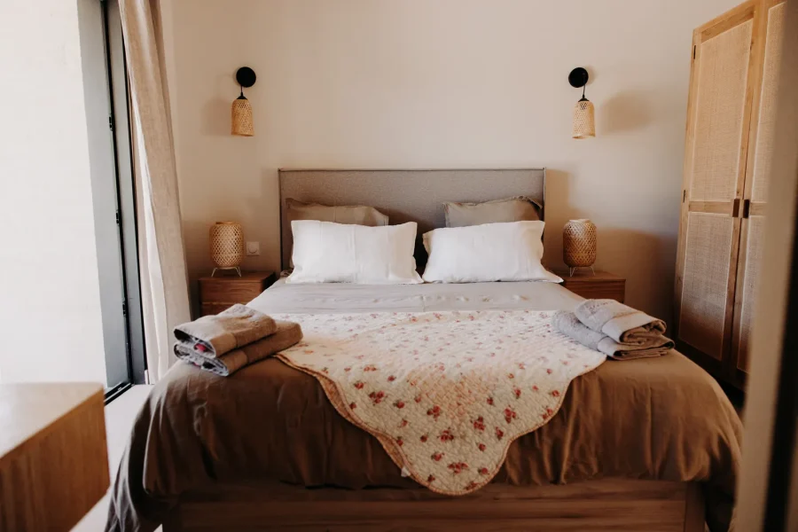 La chambre du rez-de-chaussée : lit double, lampes de chevet en rotin