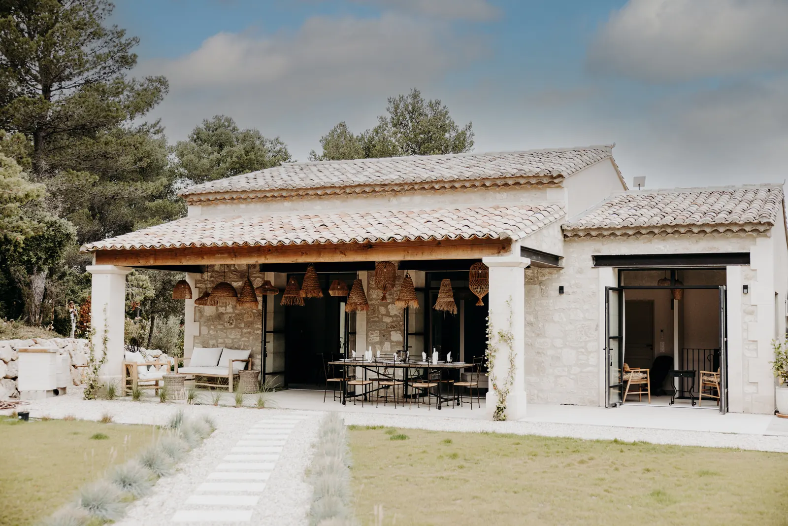 L'allée du jardin mène à la maison en pierre et à sa terrasse couverte, point de départ des balades