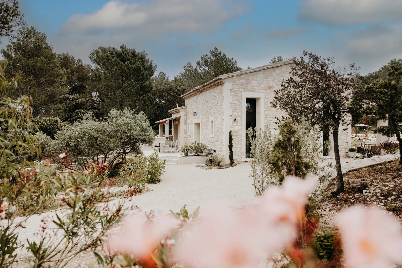 Le côté ouest de la maison en pierre, entre fleurs et oliviers