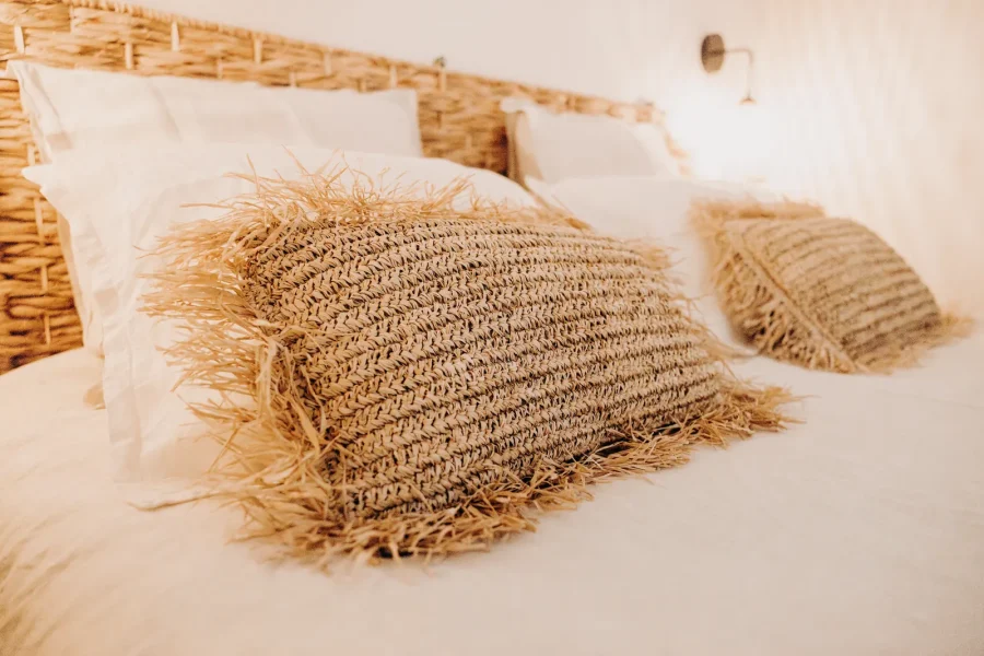 Coussins en fibres naturelles sur le lit d'une chambre de l'étage