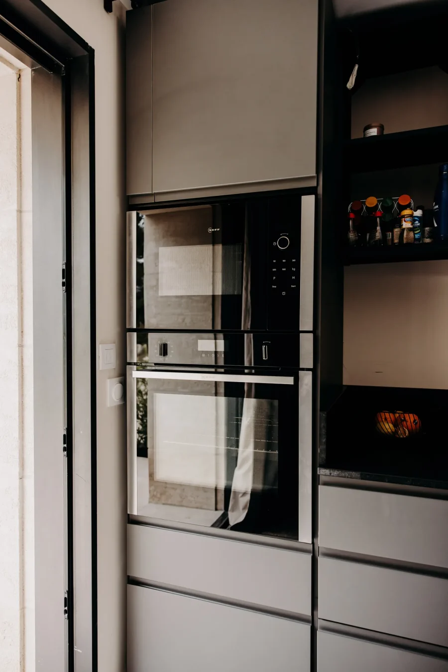 La cuisine, ses fours et ses façades sombres
