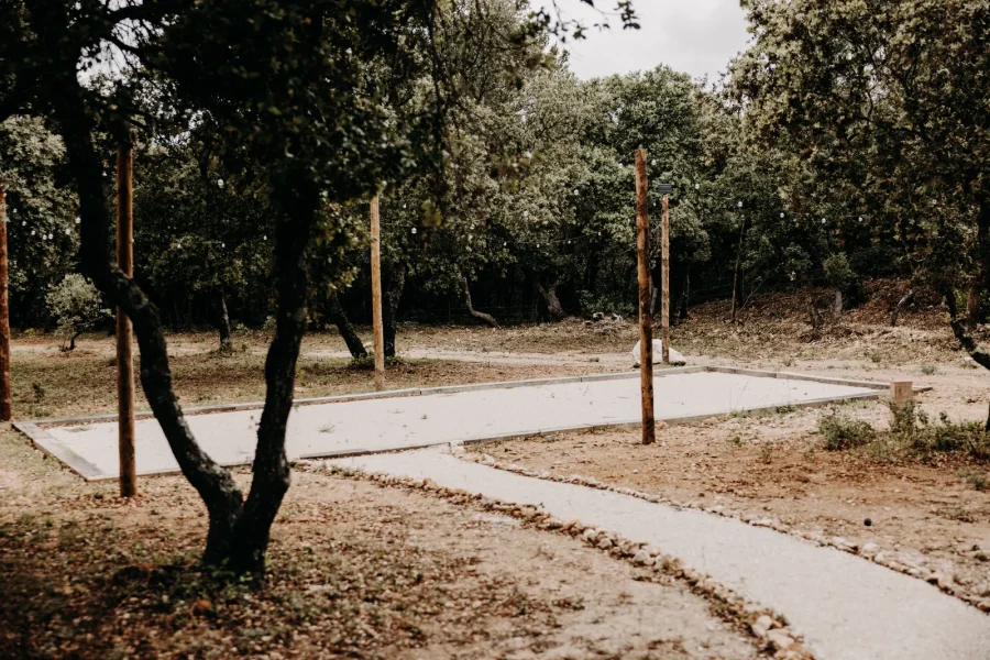 Le terrain de pétanque sous les oliviers et les pins