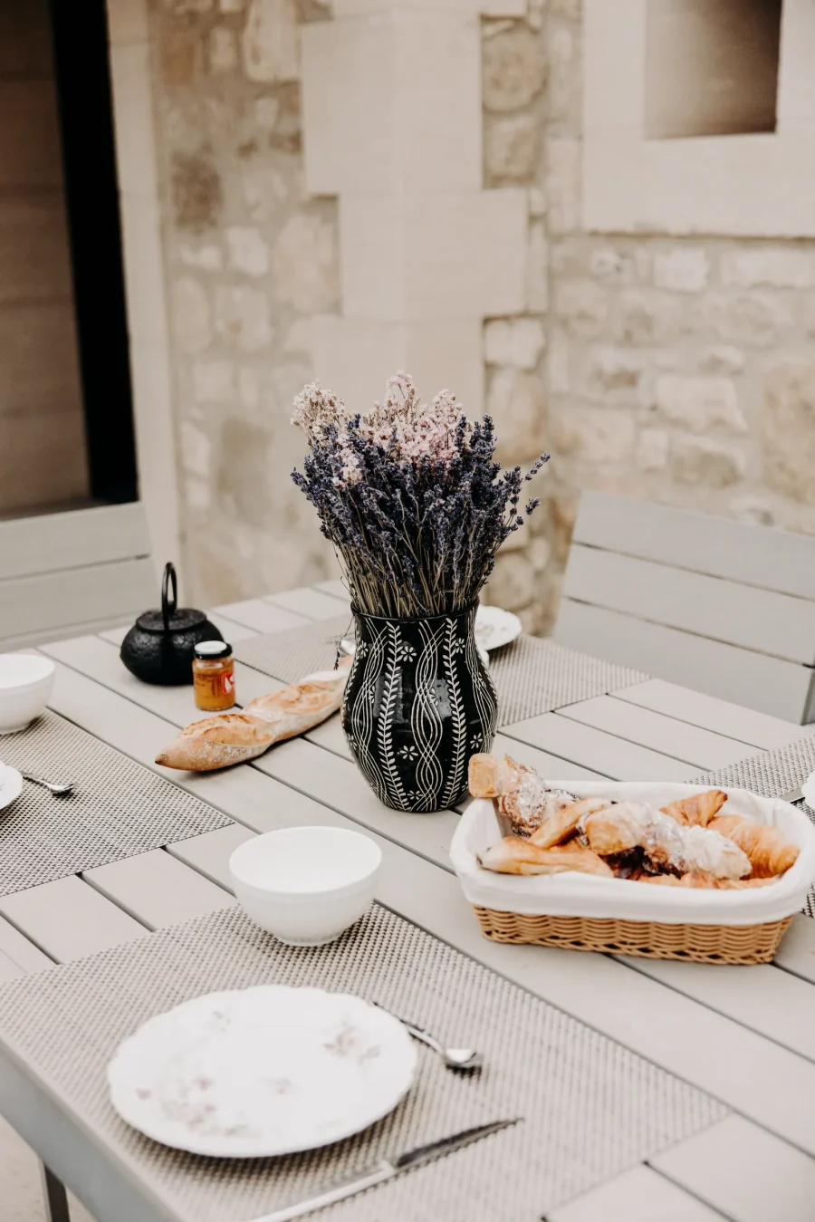 Pain, confitures et bouquet de lavande sur la table de la terrasse nord