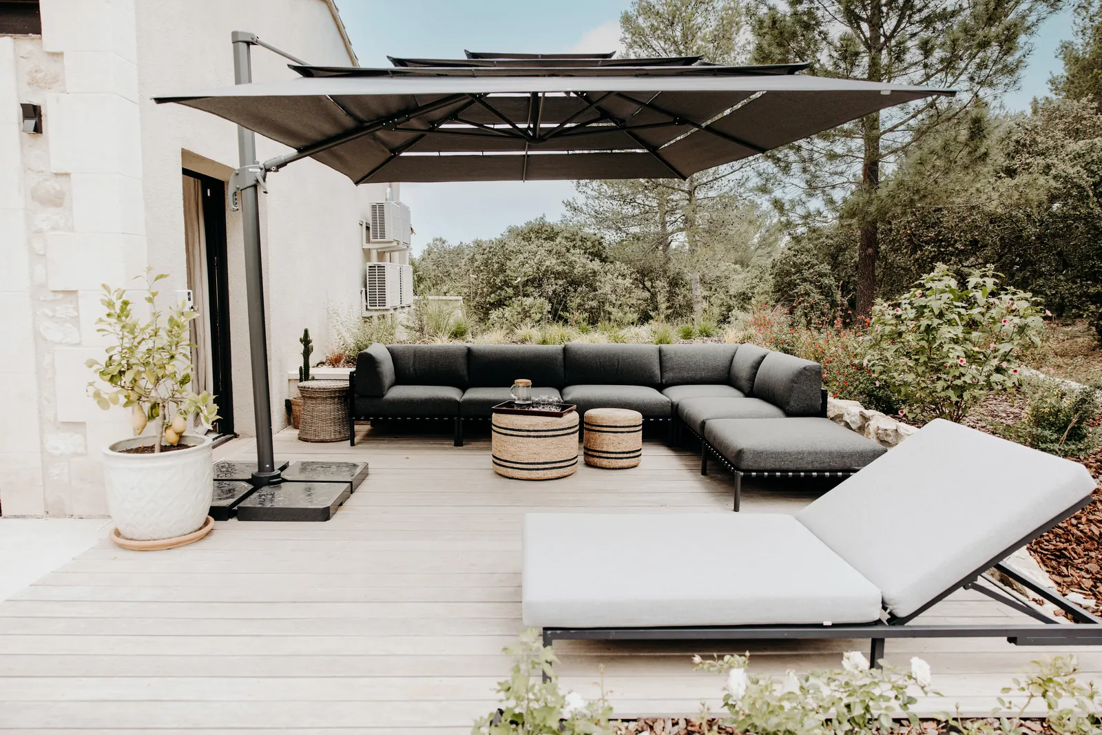 Le salon d'extérieur de la terrasse est, canapé d'angle et bain de soleil sous le parasol